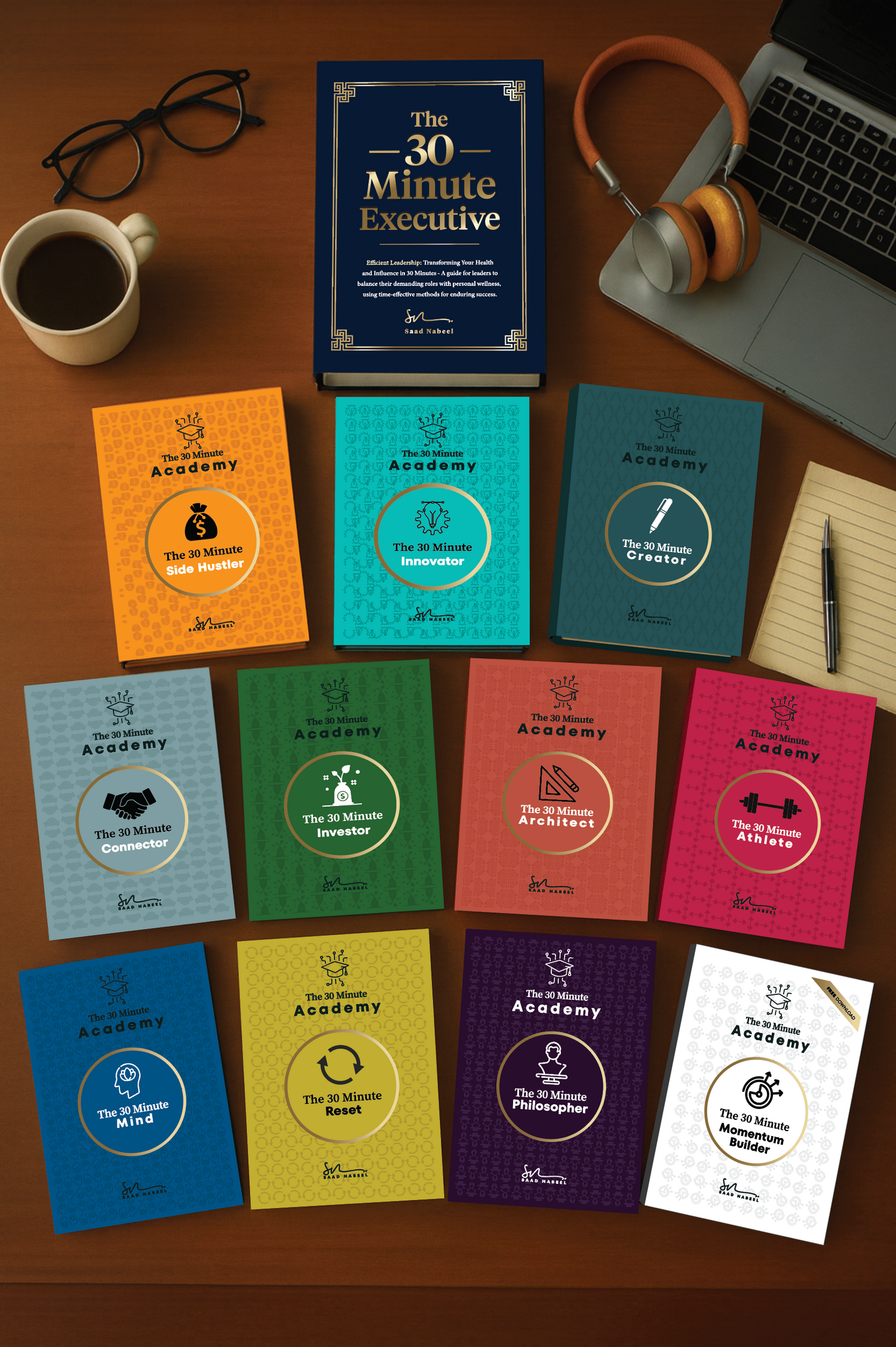 Collection of books on a desk with a cup, glasses, and laptop.